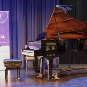 piano on stage with leduc music festival banner in the background