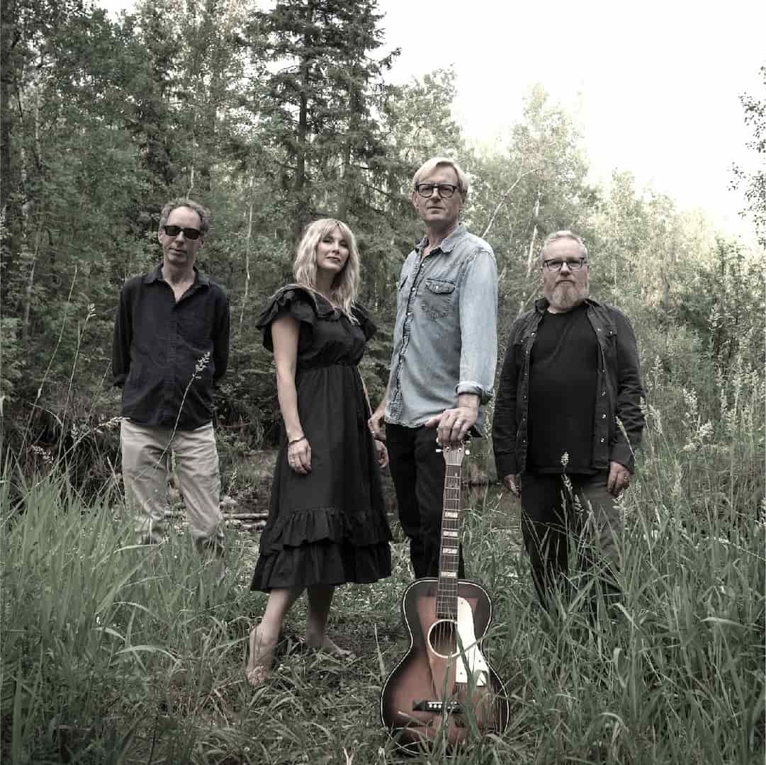 Everett LaRoi band group photo in the forest holding a guitar