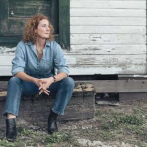 Photo of Kathleen Edwards sitting in front of old building.