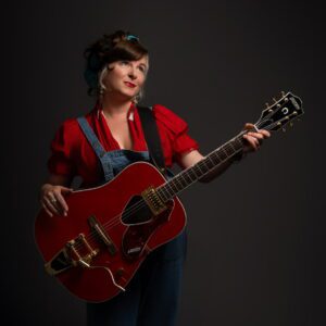 Little Miss Higgins posing with guitar