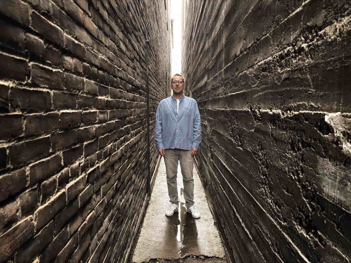 Mark Davis standing in a narrow alley
