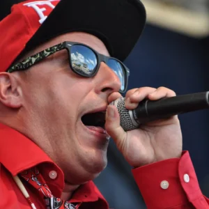 Rellik holding a microphone while performing on stage