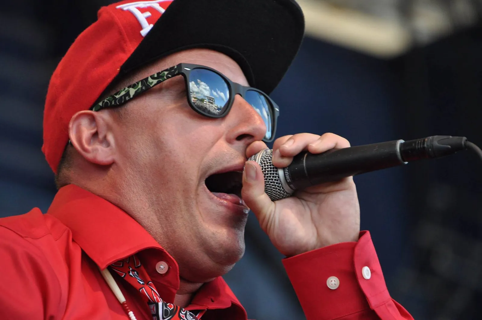 Rellik holding a microphone while performing on stage